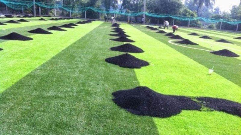 Trải hạt cao su và hoàn thiện bề mặt sân cỏ nhân tạo